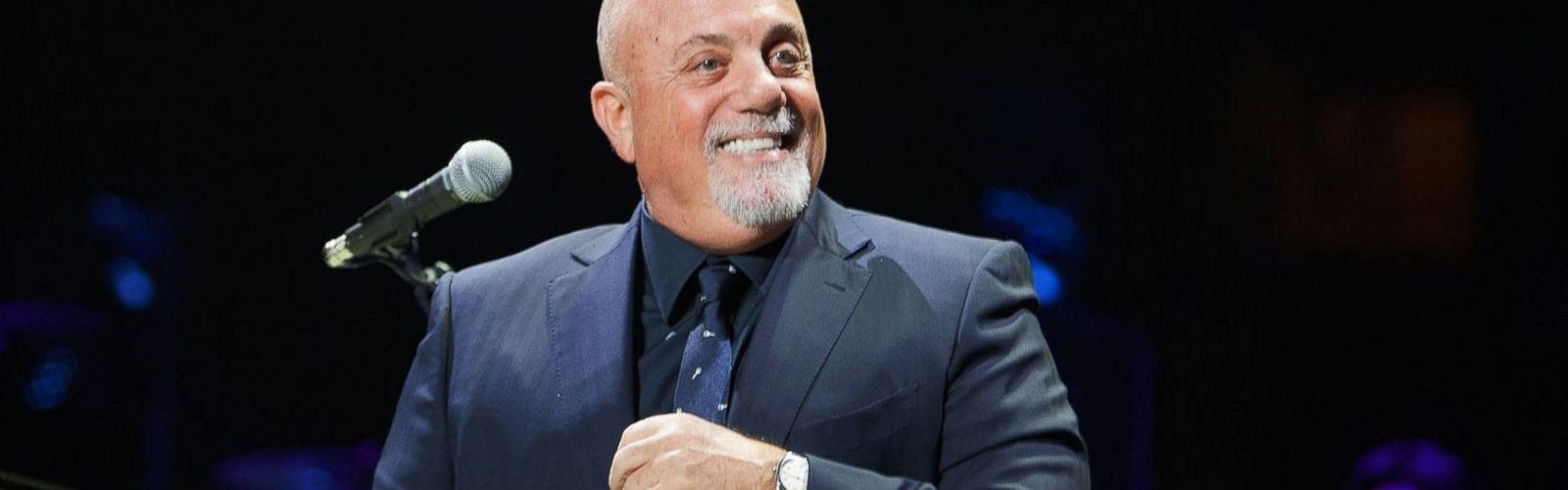 Billy Joel on stage in front of a microphone
