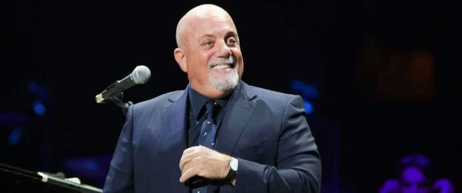 Billy Joel on stage in front of a microphone