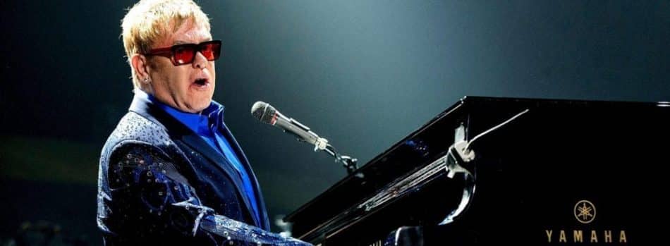 elton john at a piano elton john postponed shows after a covid diagnosis this week