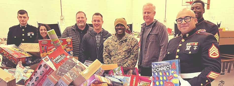 TicketNetwork staff posing with members of the Navy and marine Corps reserve at the toys for tots program drop off.