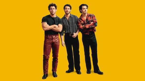 Jonas Brothers Tour dates 2023 photo of the three brothers against a yellow background