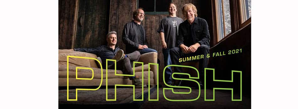 Phish Summer + Fall 2021 Tour Graphic - the four band members posing in front of a wood wall, with the band name superimposed over the photo.